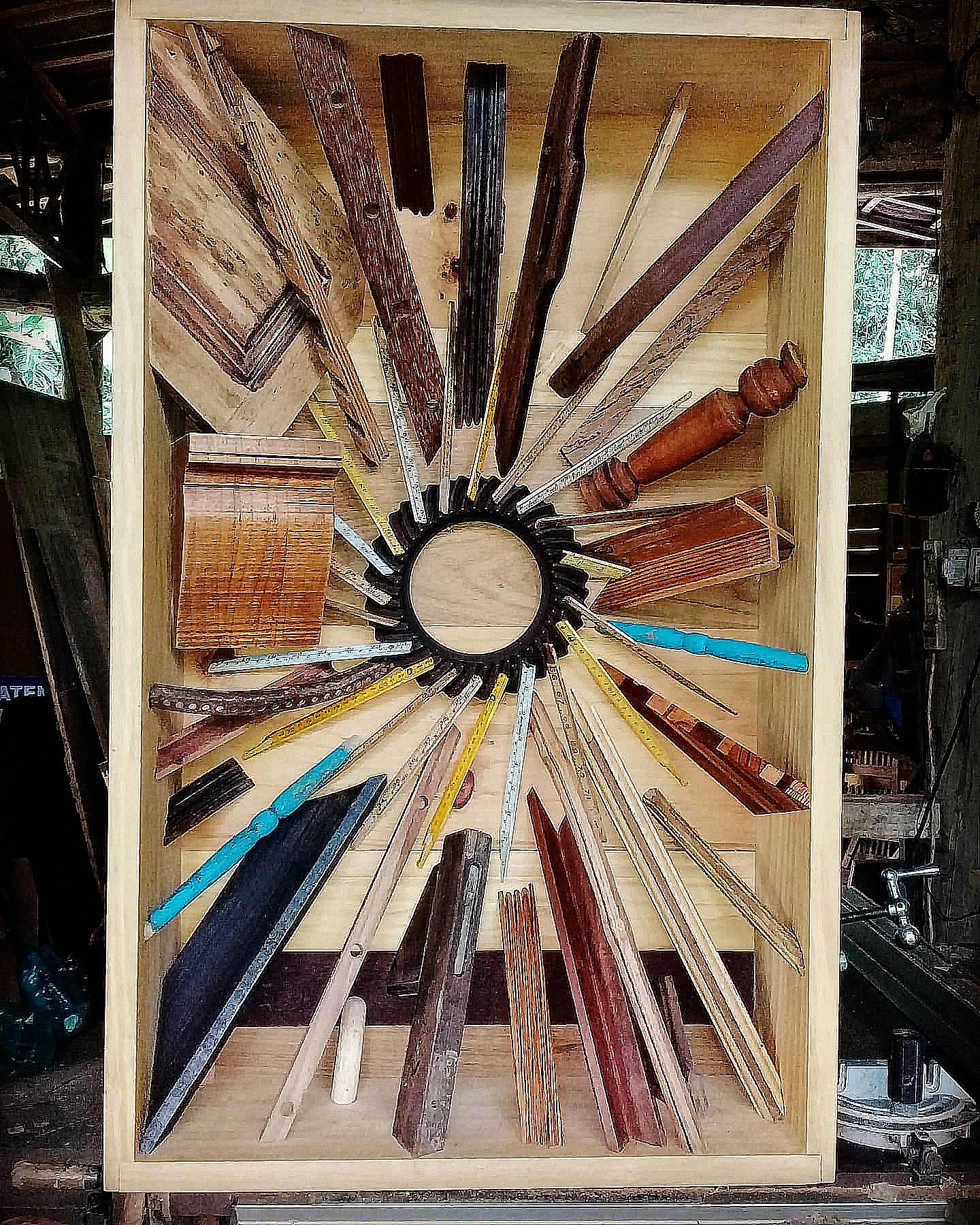 The work Caixa 012 brings together wooden pieces and rulers arranged in a circle inside a rectangular frame.