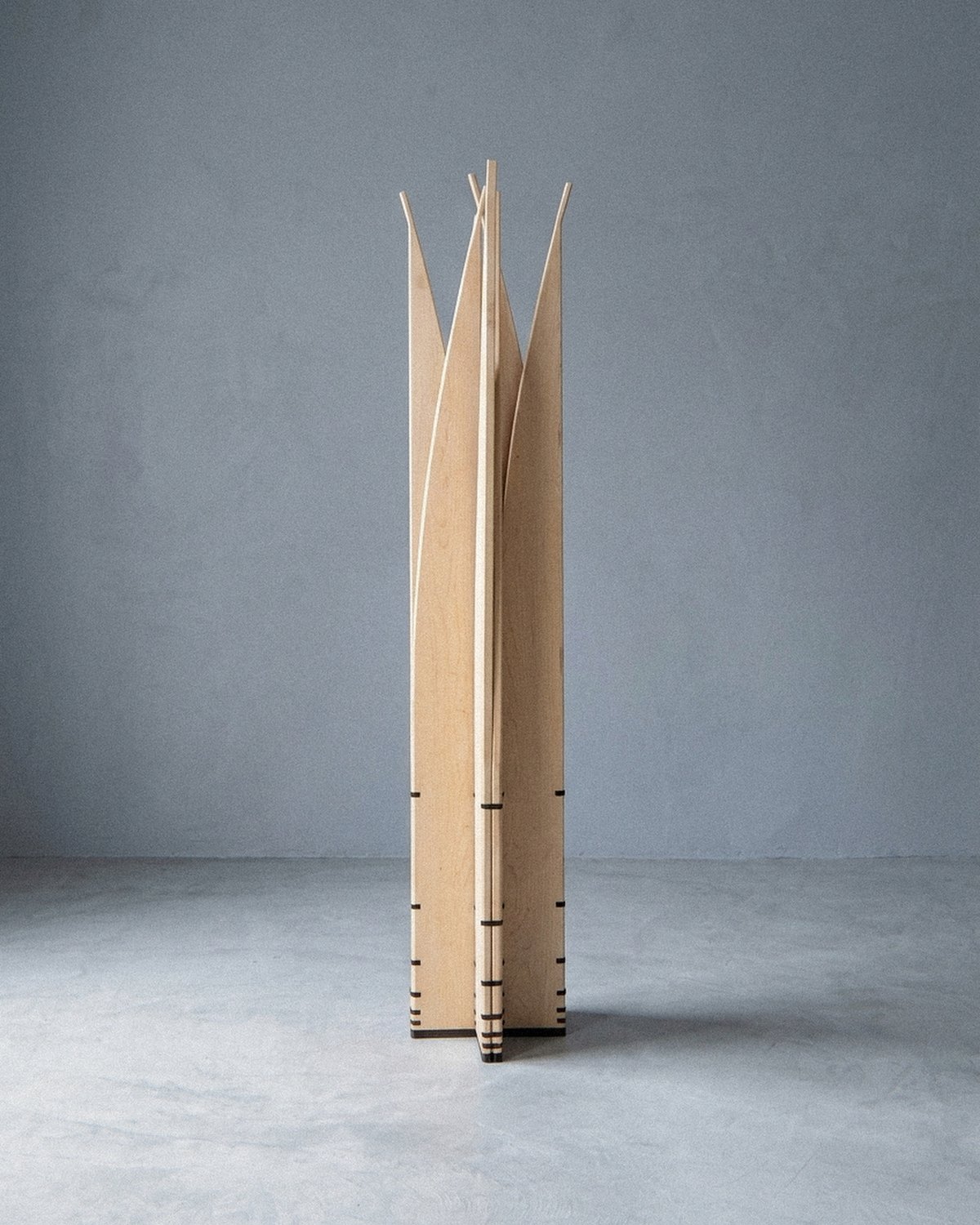 The mobile sculpture Velas standing at a distance, arranged in a radial star column with upright pointed blades.