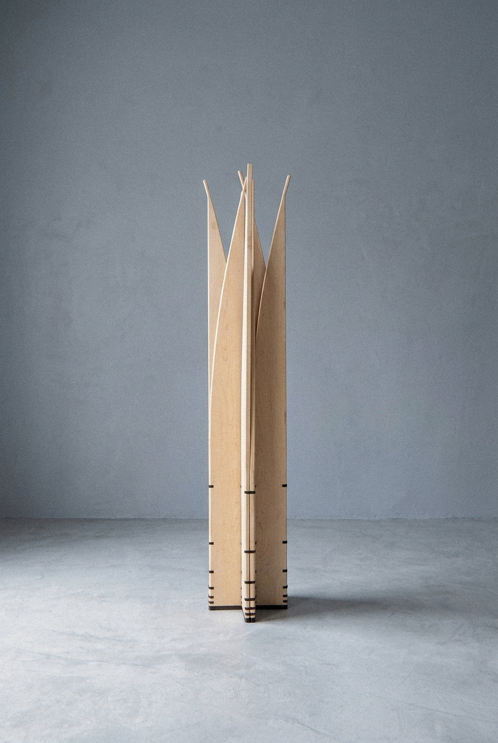 The mobile sculpture Velas standing at a distance, arranged in a radial star column with upright pointed blades.